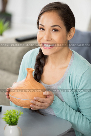 beautiful woman holdingwith wooden essential oil aroma diffuser. Стоковое фото, агентство Ingram Publishing / Фотобанк Лори
