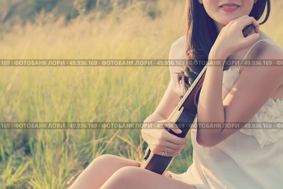 Beautiful Woman sitting  hand hugs violin in the meadow. Стоковое фото, агентство Ingram Publishing / Фотобанк Лори