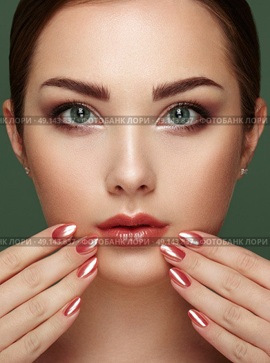Beauty brunette woman with perfect makeup. Glamour girl. Red lips and nails. Perfect eyebrows. Skin care foundation. Beauty girls face isolated on green background. Fashion photo. Стоковое фото, агентство Ingram Publishing / Фотобанк Лори