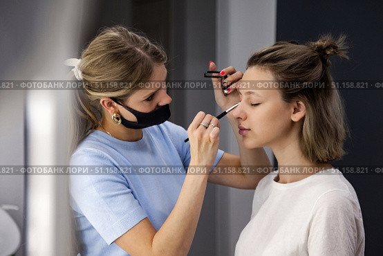 Beauty Transformation Takes Place in a Cozy Salon as a Woman is Pampered by a Skilled Make-Up Artist. Стоковое фото, фотограф Aleksandr Golubev / Фотобанк Лори