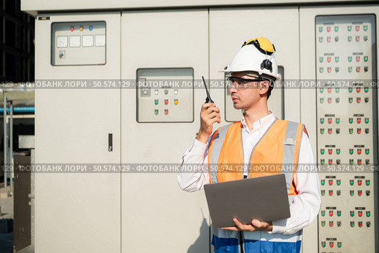 Before proceeding with the testing, Electrical engineer inspects the installed control panel. Стоковое фото, агентство Ingram Publishing / Фотобанк Лори