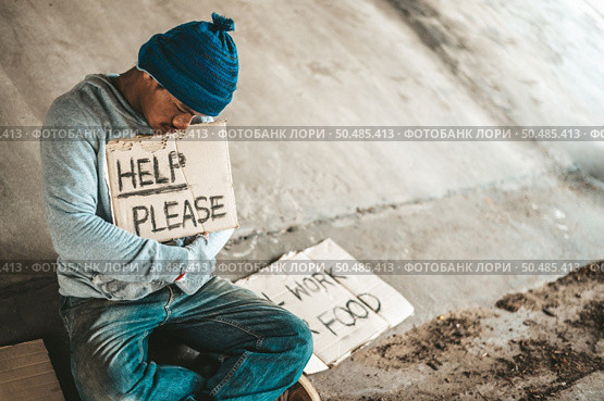 Beggars sitting under the bridge with a sign, help please. Стоковое фото, агентство Ingram Publishing / Фотобанк Лори