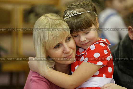 Belarus, the city of Gomel, February 26, 2016. Graduation in kindergarten.The little daughter hugs Mom. Family scene. Maternal feeling. Редакционное фото, фотограф Лазаренко Светлана / Фотобанк Лори