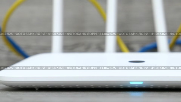 Белый беспроводной Wi-Fi маршрутизатор или роутер и кабели на белом столе. Съёмка в движении. Стоковое видео, видеограф Евгений Ковальский / Фотобанк Лори