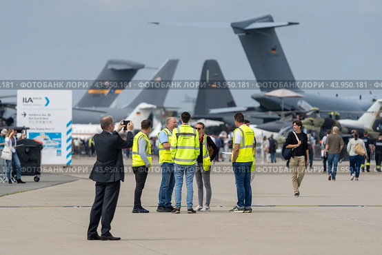 BERLIN - JUNE 07, 2024: Workers and visitors on the airfield. ILA Berlin Air Show. Редакционное фото, фотограф Sergey Kohl / Фотобанк Лори