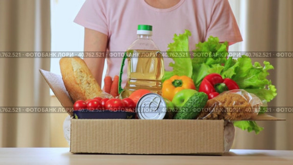 Безликая женщина ставит коробку с продуктами питания на стол. Набор различных продуктов. Концепция службы доставки на дом, покупок или коробки с пожертвованием. Фокус на передний план. Стоковое видео, видеограф Светлана Ельцова / Фотобанк Лори