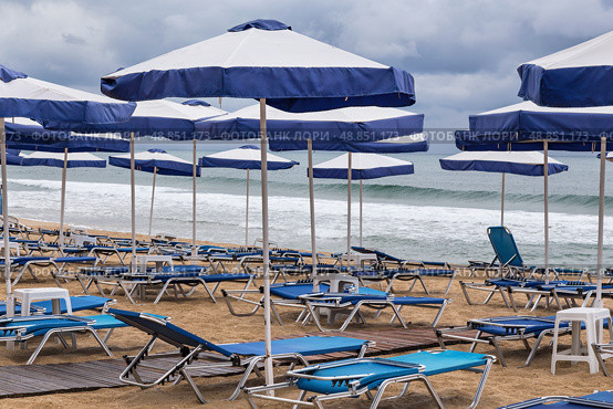 Безлюдный песчаный пляж в штормовую погоду. Sandy beach, deck chairs and beach umbrellas in stormy weather. Стоковое фото, фотограф Лариса Гордеева / Фотобанк Лори