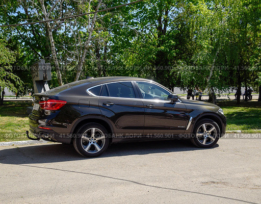 Black BMW X6 is parked in the park. A sports car of a premium cl (2017 год). Редакционное фото, фотограф Леонид Еремейчук / Фотобанк Лори