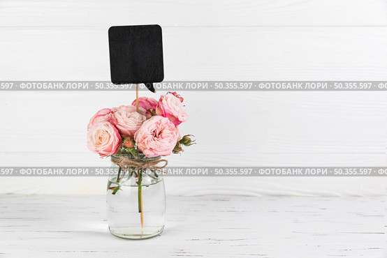 black speech bubble prop rose glass jar against white wooden backdrop. Стоковое фото, агентство Ingram Publishing / Фотобанк Лори