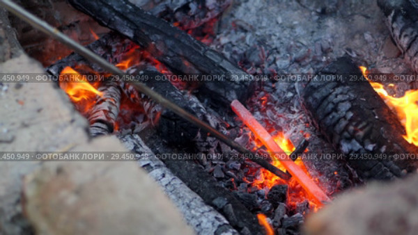 Blacksmith works metal. Craftsman, the Highlander on private smithy in the village. Burning logs in the blacksmith's furnace. Removing the preform from scorching hot crucible, using the poker. Slow motion. Стоковое видео, видеограф Константин Мерцалов / Фотобанк Лори