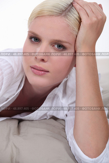 Blond woman laid on bed. Стоковое фото, агентство Ingram Publishing / Фотобанк Лори
