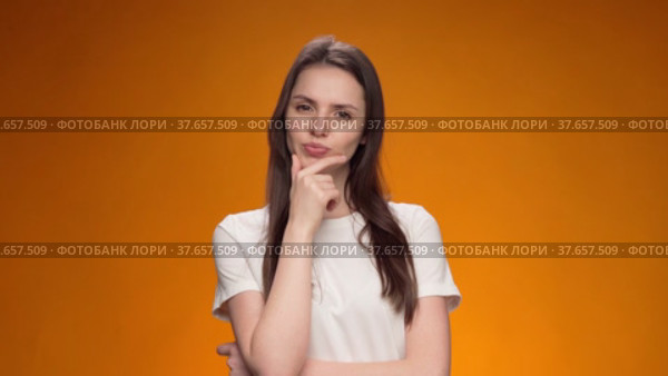 Blonde woman thinking over smart idea, pondering, against yellow background. Стоковое видео, видеограф Сергей Толмачёв / Фотобанк Лори