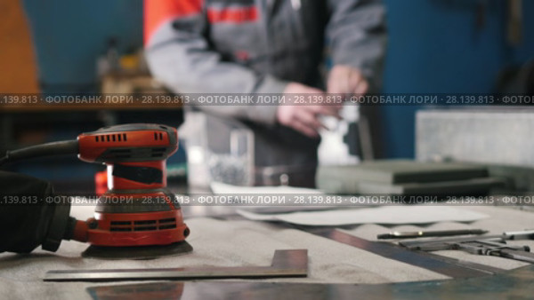 Blurred worker assembling the metal part by hand with pliers, tools for grinding metal and metal details in the foreground. Стоковое видео, видеограф Константин Шишкин / Фотобанк Лори