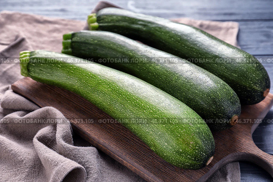 Board with ripe zucchinis on table, closeup. Стоковое фото, фотограф Pixel_shot / Фотобанк Лори