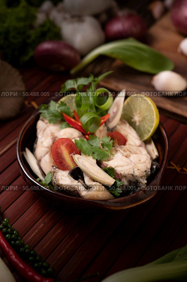 Boil the fish infusion with tomatoes, mushrooms, coriander, spring onion and lemongrass in a bowl. Стоковое фото, агентство Ingram Publishing / Фотобанк Лори