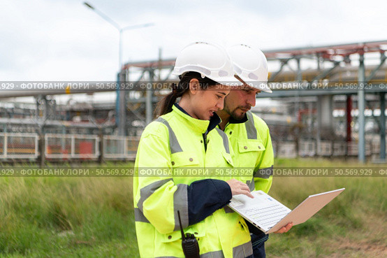Both of Petroleum engineer is on a mission to inspect oil distillation at a huge oil refinery. Стоковое фото, агентство Ingram Publishing / Фотобанк Лори