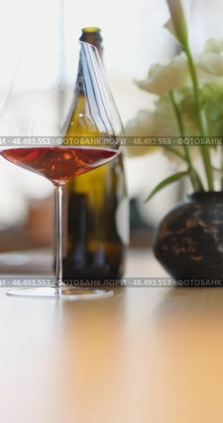 bottle of rose champagne is on table, flowers, wine glass in the restaurant, local lighting, wine cabinet, decanters for sparkling wine. Стоковое видео, видеограф Vladimir Drozdin / Фотобанк Лори