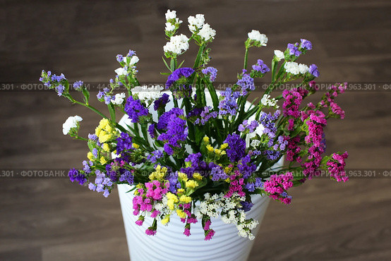 Bouquet of multicolored flowers in a vase (Limonium sinuatum, Statice sinuata) on a green background. Стоковое фото, фотограф Ирина Вершинская / Фотобанк Лори