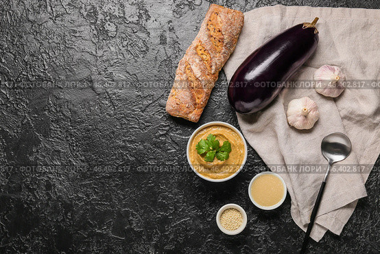 Bowl with tasty baba ghanoush and ingredients on dark background. Стоковое фото, фотограф Pixel_shot / Фотобанк Лори