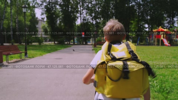 Boy schoolboy goes to school with a backpack. Стоковое видео, видеограф Igor Skripachev / Фотобанк Лори