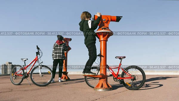 boys with bicycles looking through telescopes outdoors. Стоковое фото, агентство Ingram Publishing / Фотобанк Лори