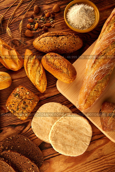 Bread fresh varied mix on golden rustic wood golden table. Стоковое фото, агентство Ingram Publishing / Фотобанк Лори