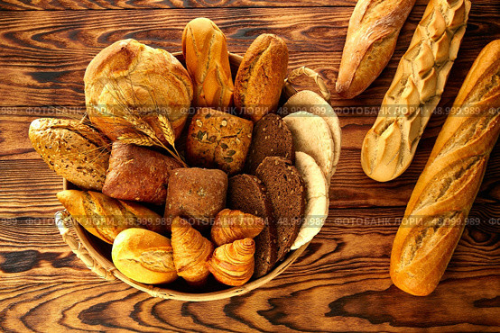 Bread fresh varied mix on golden rustic wood in basket. Стоковое фото, агентство Ingram Publishing / Фотобанк Лори