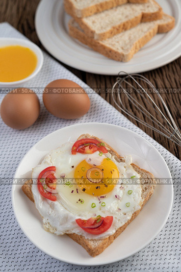 Bread placed with a fried egg with tomatoes, tapioca flour and sliced ??spring onions. Стоковое фото, агентство Ingram Publishing / Фотобанк Лори