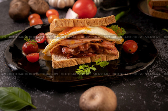 Breakfast sandwich made with bread, fried egg, ham, and lettuce. Стоковое фото, агентство Ingram Publishing / Фотобанк Лори