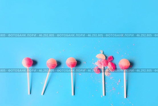 Broken lollipop among whole ones on color background. Concept of uniqueness. Стоковое фото, фотограф Pixel_shot / Фотобанк Лори