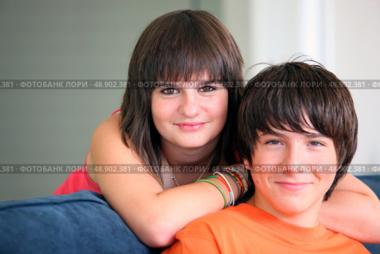 Brother and sister sat on couch. Стоковое фото, агентство Ingram Publishing / Фотобанк Лори