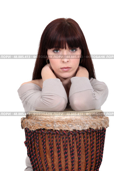 Brunette leaning on bongo drum. Стоковое фото, агентство Ingram Publishing / Фотобанк Лори