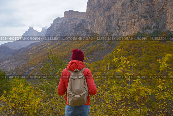 Brunette woman with a backpack on her back outdoors exploring the Caucasus Mountains in Russia, traveling, lifestyle, hiking, active autumn holidays, hiking. Стоковое фото, фотограф Екатерина Золина / Фотобанк Лори
