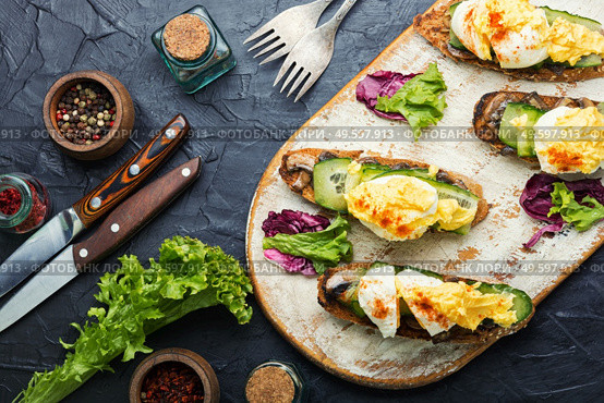 Bruschetta with poached egg,cucumber and fried mushrooms with hollandaise sauce.Tasty eggs benedict. Eggs benedict with stewed mushrooms. Стоковое фото, агентство Ingram Publishing / Фотобанк Лори