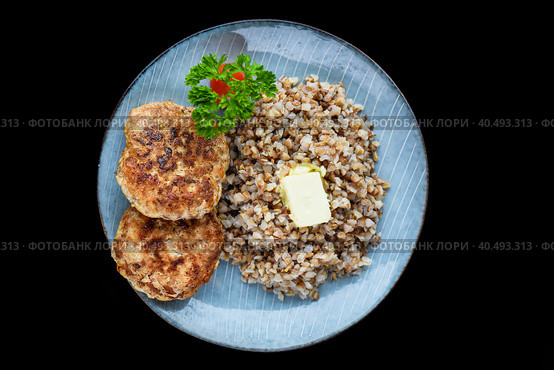 buckwheat with meat cutlets on a black background side view. Стоковое фото, фотограф Татьяна Терехина / Фотобанк Лори