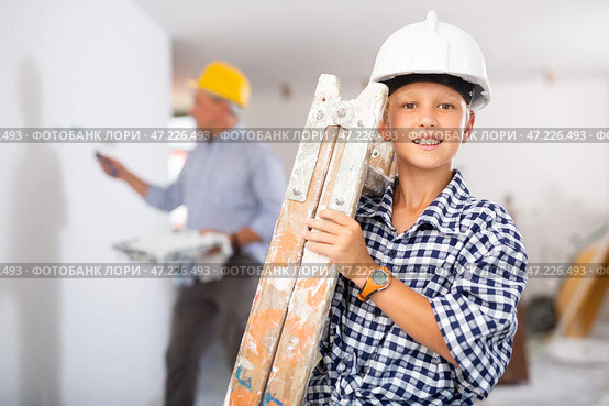 Builder boy carries a ladder. Helping parents to renovate room. Стоковое фото, фотограф Яков Филимонов / Фотобанк Лори