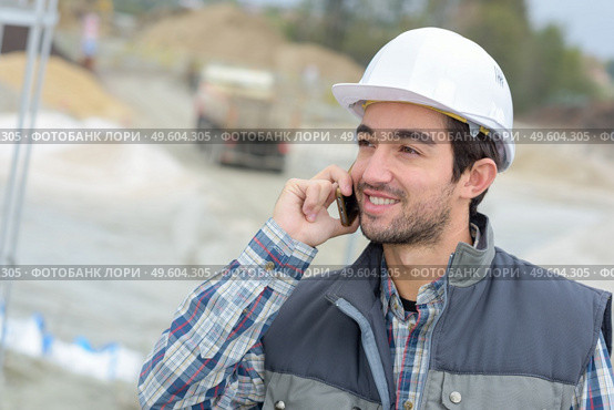 builder in hardhats on the phone outdoors. Стоковое фото, агентство Ingram Publishing / Фотобанк Лори