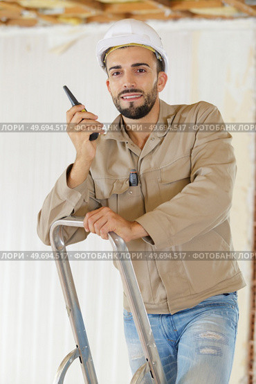 builder talking on portable uhf radio transceiver. Стоковое фото, агентство Ingram Publishing / Фотобанк Лори