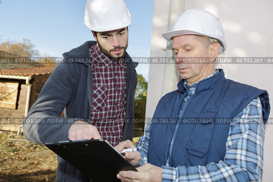 builders preparing estimate for exterior home improvement. Стоковое фото, агентство Ingram Publishing / Фотобанк Лори