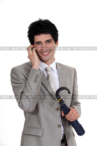 Businessman holding an umbrella and talking on a mobile phone. Стоковое фото, агентство Ingram Publishing / Фотобанк Лори