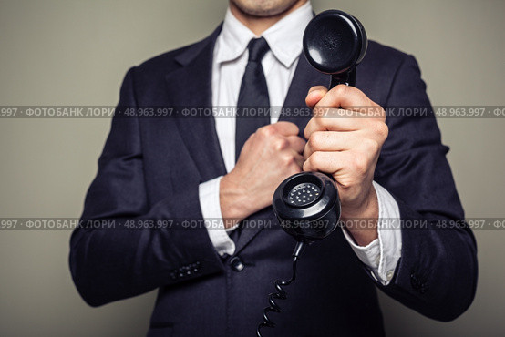 Businessman is handing over a telephone receiver. Стоковое фото, агентство Ingram Publishing / Фотобанк Лори