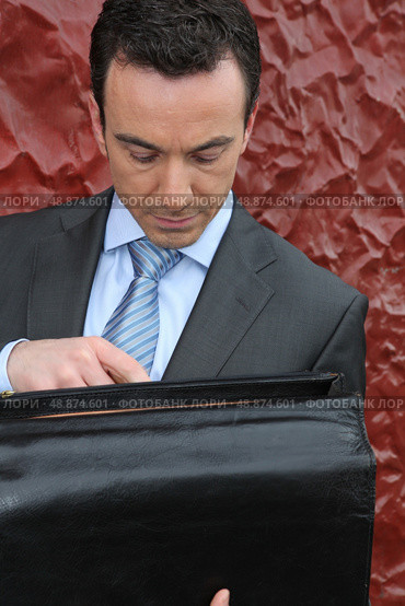 Businessman looking in his briefcase. Стоковое фото, агентство Ingram Publishing / Фотобанк Лори