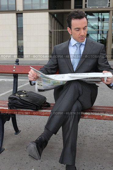 Businessman reading a newspaper on a bench. Стоковое фото, агентство Ingram Publishing / Фотобанк Лори