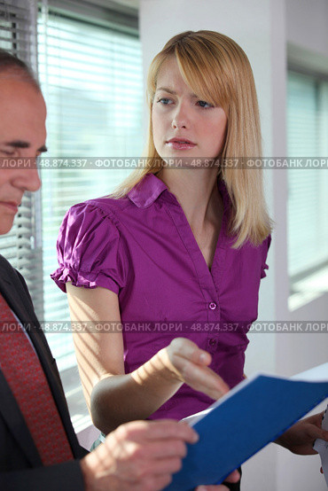 Businesswoman explaining document to colleague. Стоковое фото, агентство Ingram Publishing / Фотобанк Лори