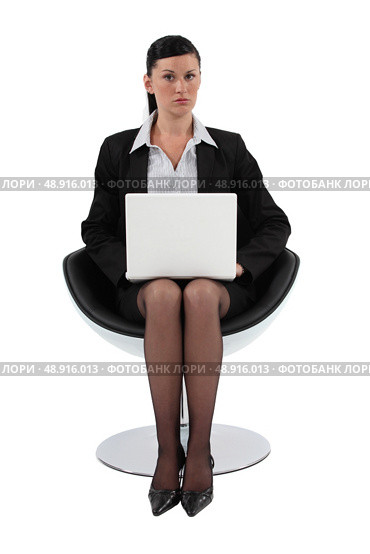 Businesswoman sitting in a modern chair and using her laptop. Стоковое фото, агентство Ingram Publishing / Фотобанк Лори