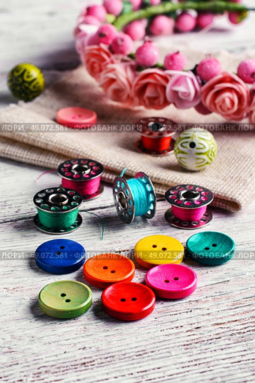 Buttons of different colors and accessories for needlework. Bright buttons and thread. Стоковое фото, агентство Ingram Publishing / Фотобанк Лори