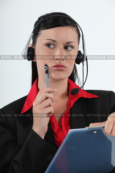 Call centre agent considering her options. Стоковое фото, агентство Ingram Publishing / Фотобанк Лори