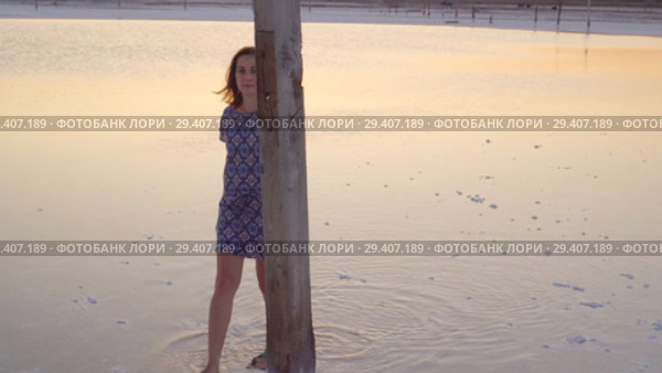 Calm girl enjoying sun, walking slowly through the water of a salt lake. Стоковое видео, видеограф Ирина Мойсеева / Фотобанк Лори