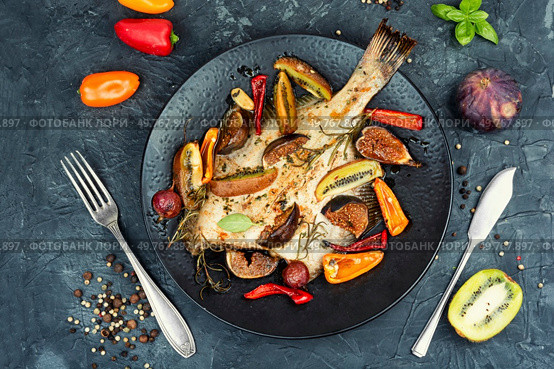 Cambala fish in a fruit marinade on a concrete kitchen table. Fish, flounder fish baked or fried with figs, kiwi and sharp pepper. Flat lay. Cambala fish in a fruit marinade. Стоковое фото, агентство Ingram Publishing / Фотобанк Лори