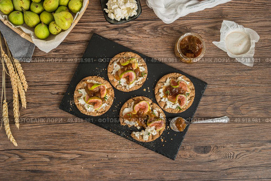 Canape or crostini with multigrain  crispread with cream cheese and fig jam on a slate board. Delicious appetizer ideal as an aperitif. Стоковое фото, агентство Ingram Publishing / Фотобанк Лори